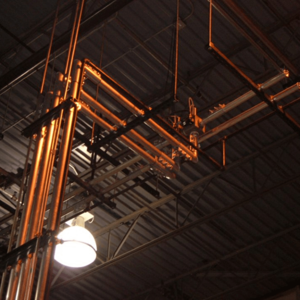 Overhead industrial piping and tubing system designed for material conveying, ensuring efficient, reliable, and easy-to-maintain operations in manufacturing and processing facilities.